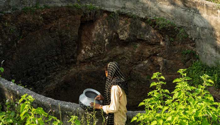 Ramati Mangla, who dropped out of school to manage household chores, looks to fetch water from a dried-up well at Bhadal village in the drought-prone district of Nandurbar on September 25, 2025. — AFP