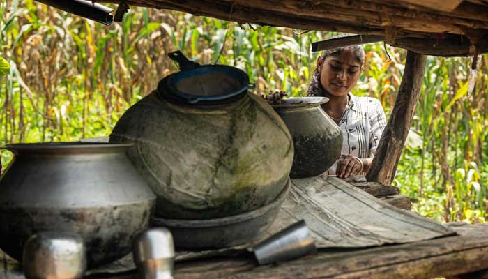 Ramati Mangla, who dropped out of school to manage household chores, checks the water stored in pots at her home in Bhadal village, in the drought-prone district of Nandurbar on September 25, 2025. — AFP