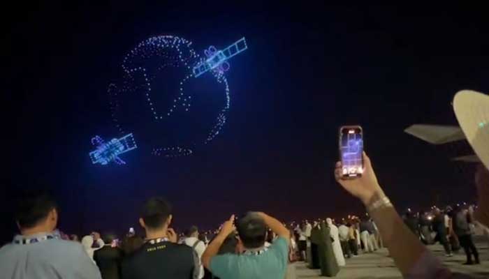 People watch an aerial display of drone formation during Dubai Airshow. — Reporter