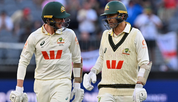Australias unbeaten pair Nathan Lyon (R) and Brendan Doggett walk back to the pavilion at the end of day 1 of the first Ashes cricket Test match between Australia and England at Perth Stadium in Perth on November 21, 2025. — AFP