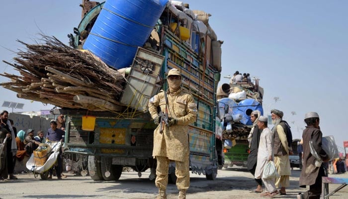 A Taliban security personnel stands guard as deported Afghan refugees from Pakistan arrive at the zero-point border crossing between Afghanistan and Pakistan, in the Spin Boldak district of Kandahar province on October 27, 2025. — AFP