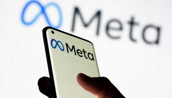 Woman holds smartphone with Meta logo in front of a displayed Facebooks new rebrand logo Meta in this illustration picture taken October 28, 2021. — Reuters