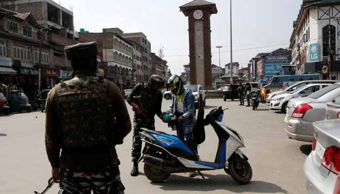 Indian Central Reserve Police Force (CRPF) personnel check the bags of a scooterist as part of security checks in IIOJK on October 12, 2021. — Reuters