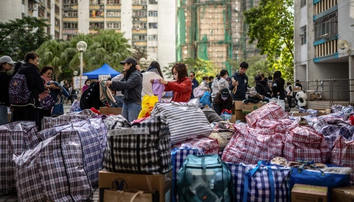 Crowds distribute daily necessities in the aftermath of a major fire that swept through several apartment blocks at the Wang Fuk Court residential estate in Hong Kongs Tai Po district on November 28, 2025. — AFP