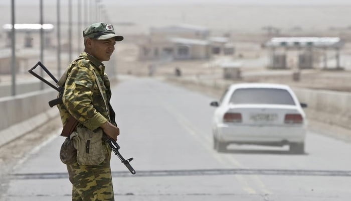 A frontier guard stands on a bridge to Afghanistan across the Panj River in Panji Poyon border outpost, south of Dushanbe, Tajikistan. — Reuters