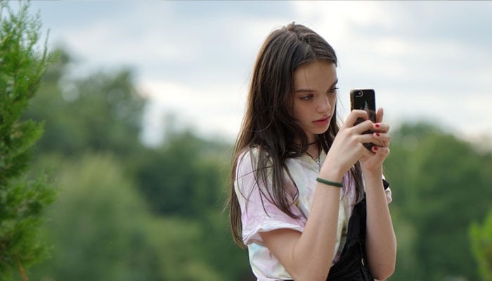A representational image of a girl taking a picture. — Canva
