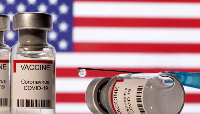 Vials labelled VACCINE Coronavirus Covid-19 and a syringe are seen in front of a displayed US flag in this illustration taken December 11, 2021. — Reuters