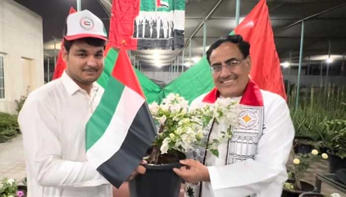 Participants pose with a sapling on the occasion of celebration of UAEs 24th National Day. — Reporter