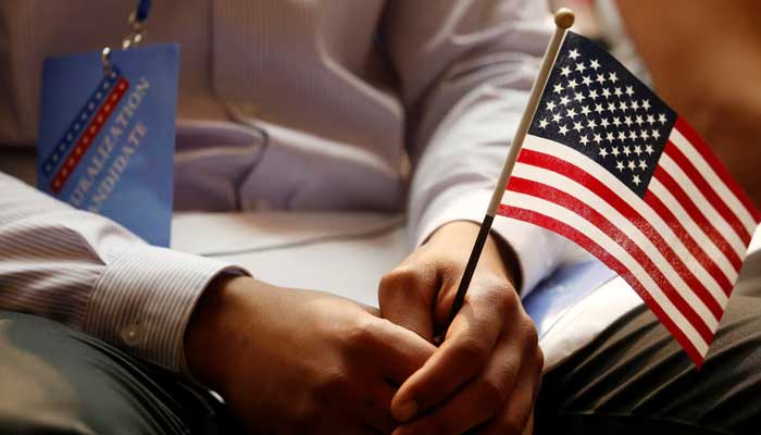 A new citizen holds a US flag at the US Citizenship and Immigration Services (USCIS) naturalisation ceremony at the New York Public Library in Manhattan, New York, US. — Reuters/File
