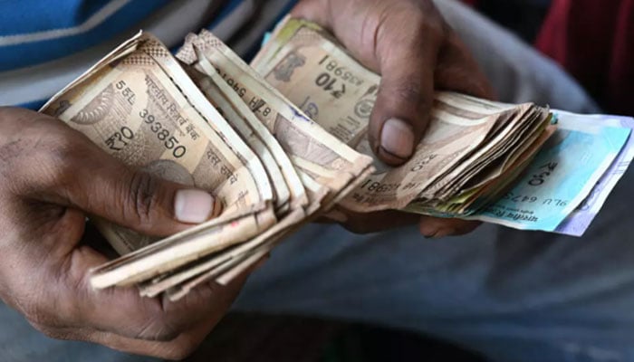 A person counting Indian currency in this undated image. — AFP