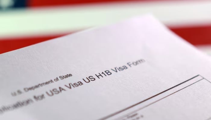 A US flag and a U.S. H-1B Visa application form are seen in this illustration taken, September 22, 2025. — Reuters