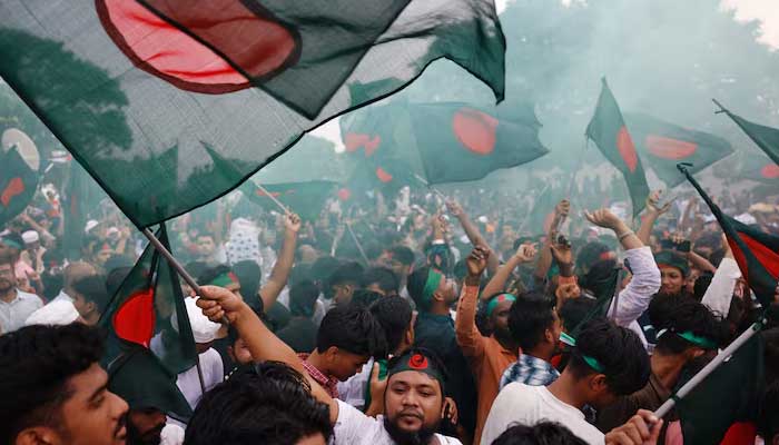People wave flags during celebrations marking the one-year anniversary of student-led protests that led to the ousting of Bangladeshi then-PM Sheikh Hasina, at Manik Mia Avenue, outside the parliament building, in Dhaka, Bangladesh on August 5, 2025. — Reuters