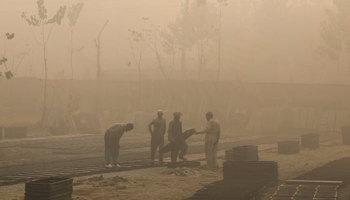 Labourers work at a brick factory during morning hours as dense smog caused by air pollution blankets Peshawar, December 2, 2025. — Reuters