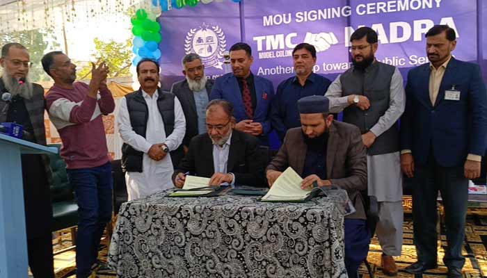 Director General Nadra, Aamir Ali Khan (left), and Model Town Chairman, Zafar Ahmed Khan, sign the Memorandum of Understanding (MoU) in Model Colony, Malir, on December 4, 2025. — Facebook/@ tmcmodelcolony