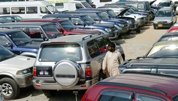 A employee of a car showroom walks amidst new cars displayed at an auto dealer centre in Karachi. — AFP/File