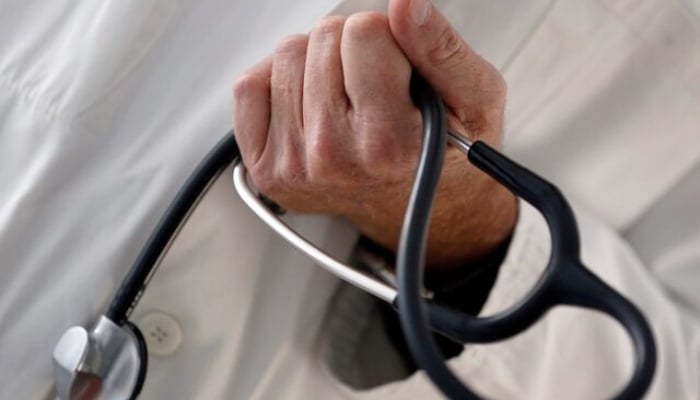 A photo illustration shows a general practitioner holding a stethoscope. — Reuters/File