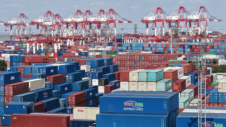 An aerial view shows stacked containers at the Shanghai Port container terminal in Shanghai on December 8, 2025. — AFP