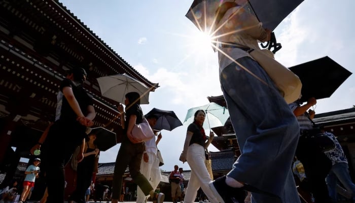 Passersby holding umbrellas walk under a strong sunlight at the Sensoji temple as Japanese government issued heat stroke alerts in 39 of the countrys 47 prefectures in Tokyo, Japan July 22, 2024. — Rueters