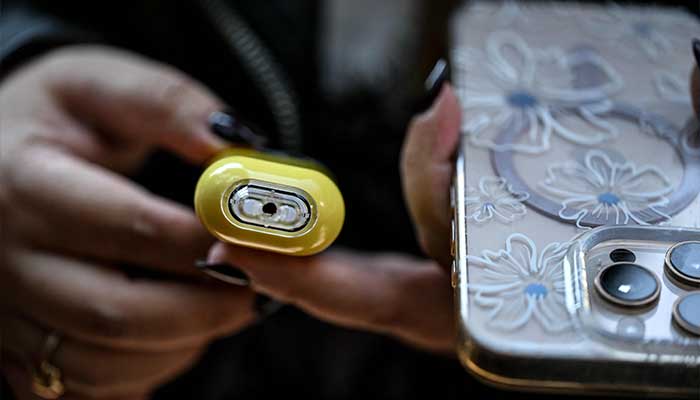 A young woman holds a vape in the La Condesa neighborhood of Mexico City on December 11, 2025. — AFP