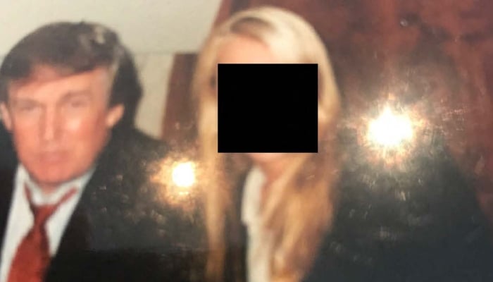 This undated photo from the personal collection of Jeffrey Epstein, provided by the Democrats on the House Oversight Committee on December 12, 2025, shows US President Donald Trump posing with a woman whose face has been redacted. — AFP