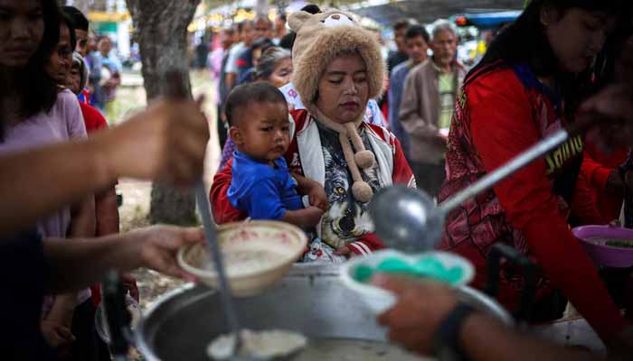 Displaced people queue for food at a school turned temporary shelter, amid clashes between Thailand and Cambodia along a disputed border area in Surin province, Thailand. — Reuters