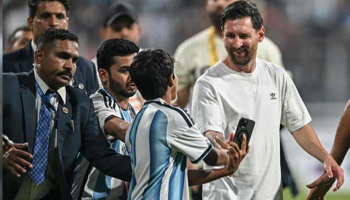 Argentinas footballer Lionel Messi (Right) interacts with a young fan during his Goat Tour at the Wankhede Stadium in Mumbai on December 14, 2025.— AFP