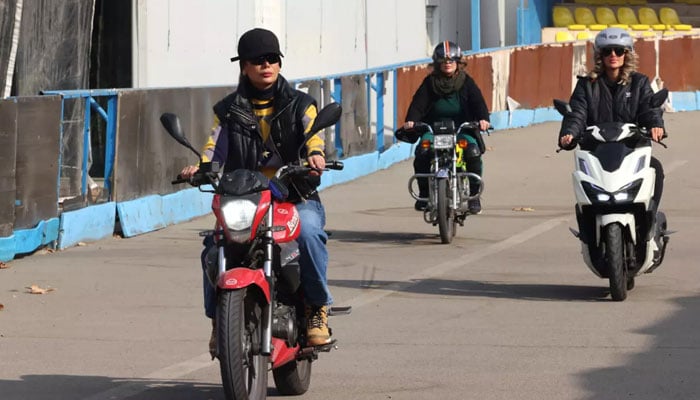 Instructor Maryam Ghelich (L) gives women students a lesson in riding motorbikes at a training centre in northern Tehran. — AFP