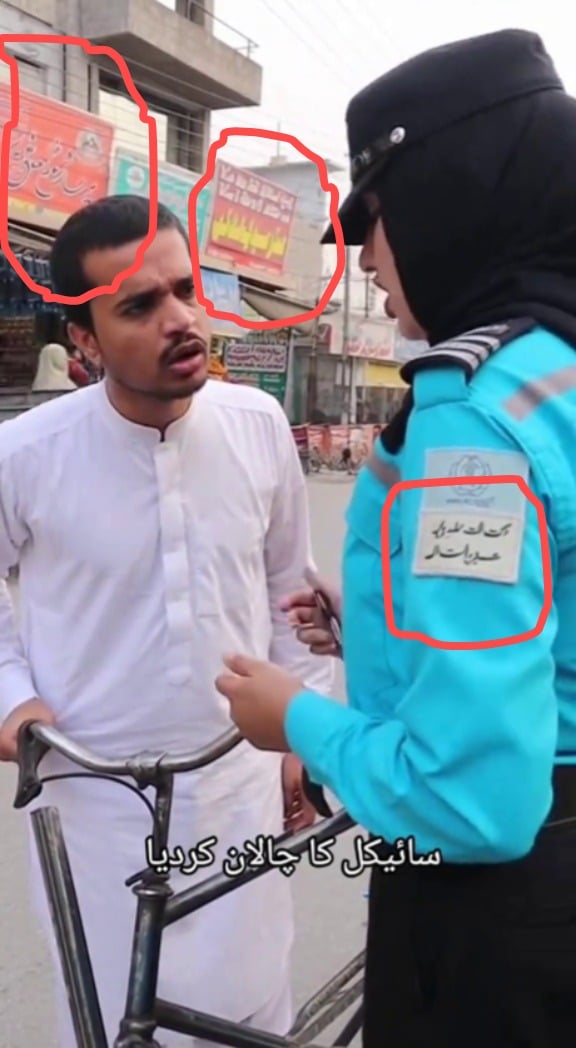 The video contains unreadable text on the traffic warden’s uniform and nearby shops.