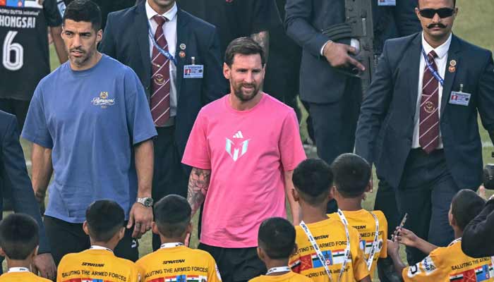 Argentinas footballer Lionel Messi (Centre), along with Uruguayan footballer Luis SuÃ¡rez (Left), arrives to attend an event during his GOAT Tour at the Arun Jaitley Stadium in New Delhi on December 15, 2025.— AFP