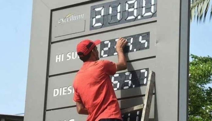 A representational image of a fuel station staffer updating the fuel prices in Karachi. — AFP/ File