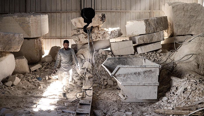 A man walks amongst large blocks of Jerusalem stone inside a factory in Beit Fajar, eight kilometres south of the Israeli-occupied West Bank city of Bethlehem on November 10, 2025. — AFP
