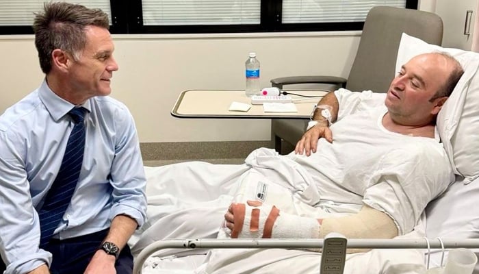 This handout photo taken and received from the NSW Premiers Department on December 15, 2025, shows New South Wales Premier Chris Minns (L) talking with Ahmed Al Ahmed, the man who tackled and disarmed one of the Bondi beach attackers, at St George Hospital in Sydney. — AFP
