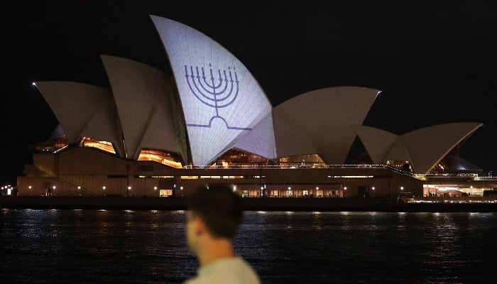 A Hanukkah menorah is projected onto the sails of the Sydney Opera House in memory of the victims of a shooting at Bondi Beach, in Sydney on December 15, 2025. — AFP