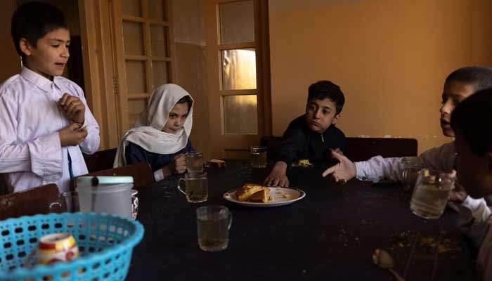 Afghan children share tea and bread for breakfast at the orphanage before going to school in Kabul, Afghanistan, October 12, 2021. — Reuters