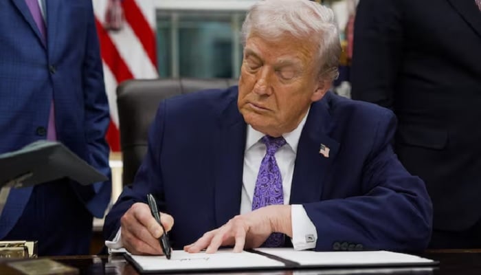 U.S. President Donald Trump signs an executive order on AI in the Oval Office at the White House in Washington, DC, US, December 11, 2025. — Reuters