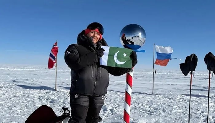 Mountaineer Samina Baig poses with a Pakistani flag at the South Pole after a successful ski expedition. — Facebook/Samina Baig