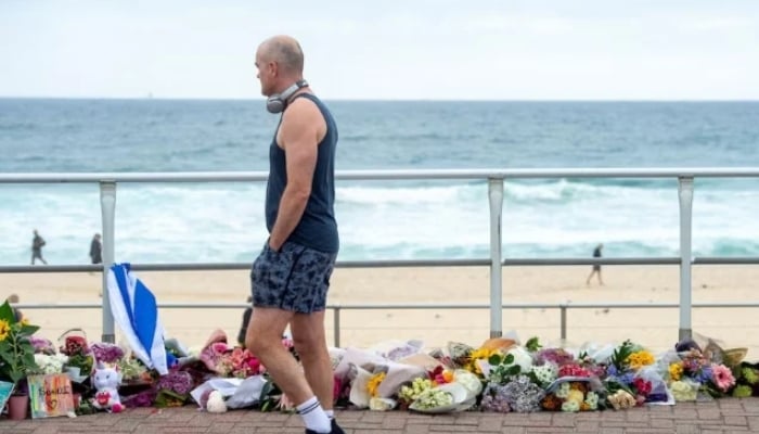 A man walks along the promenade at Bondi Beach, while looking at a floral tribute to honour the victims of a mass shooting targeting a Hanukkah celebration on Sunday at Bondi Beach, in Sydney, Australia, December 16, 2025. — Reuters