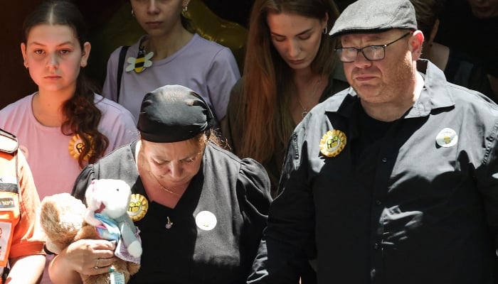 Valentyna (L), mother of 10-year-old Matilda, who was killed in the December 14 Bondi Beach shooting attack, and Matilda´s father (R) leave behind their daughter´s coffin after the funeral service in Sydney on December 18, 2025. — AFP