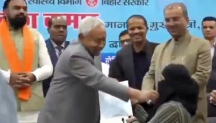 Bihar Chief Minister Nitish Kumar removes hijab of a newly recruited doctor during an official event on December 15, 2025. — X/ @SouthAsiaIndex/screengrab