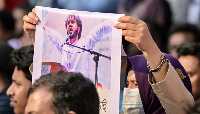 An activist holds a poster of Sharif Osman Hadi, senior leader of the student protest group Inqilab Mancha, who was shot outside a mosque, during a demonstration to condemn the attack in Dhaka on December 15, 2025. — AFP