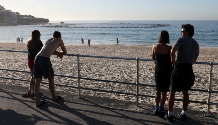 People observe as the Bondi surfing community pays tribute in the water to honour the victims of the mass shooting at Bondi Beach on Sunday, as the crime scene was reopened in Sydney, Australia, December 19, 2025. — Reuters