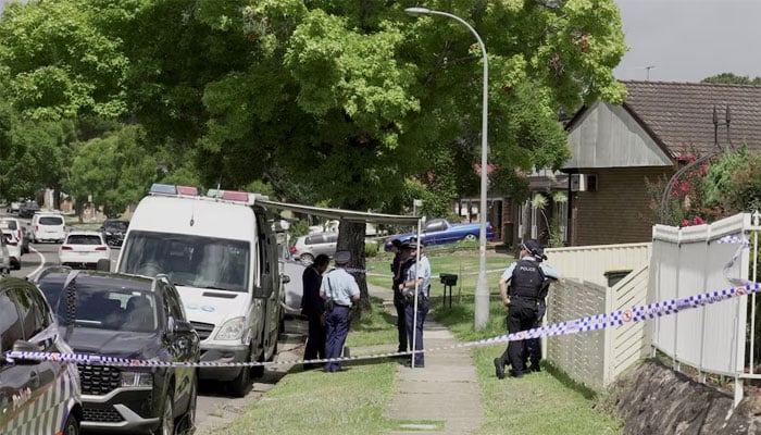 Police officers stand guard outside the house of the suspects of a shooting incident on a Jewish holiday celebration at Bondi Beach, in Bonnyrigg, Sydney, Australia, on December 15, 2025. — Reuters