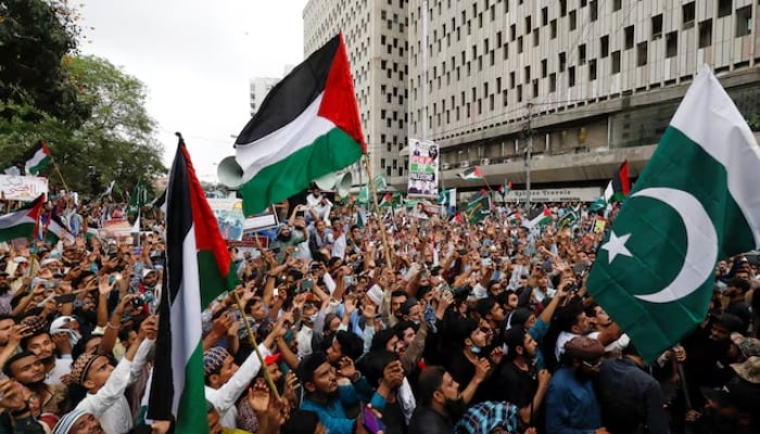 People carry flags as they chant slogans to express solidarity with Palestinian people and to protest against Israel, during a rally in Karachi on May 21, 2021. — Reuters