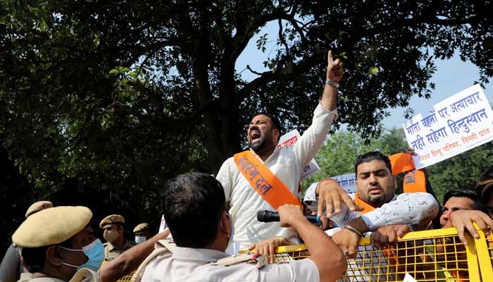 Police personnel hold a barricade against protesters in New Delhi. — Reuters