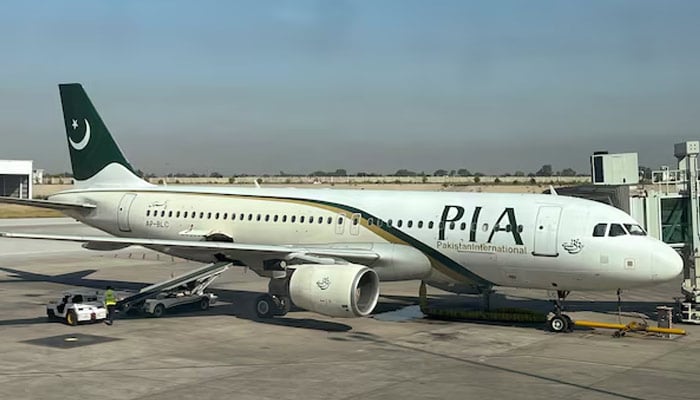 View of a Pakistan International Airlines (PIA) passenger plane, taken through a glass panel, at Islamabad International Airport, Pakistan on October 3, 2023. — Reuters