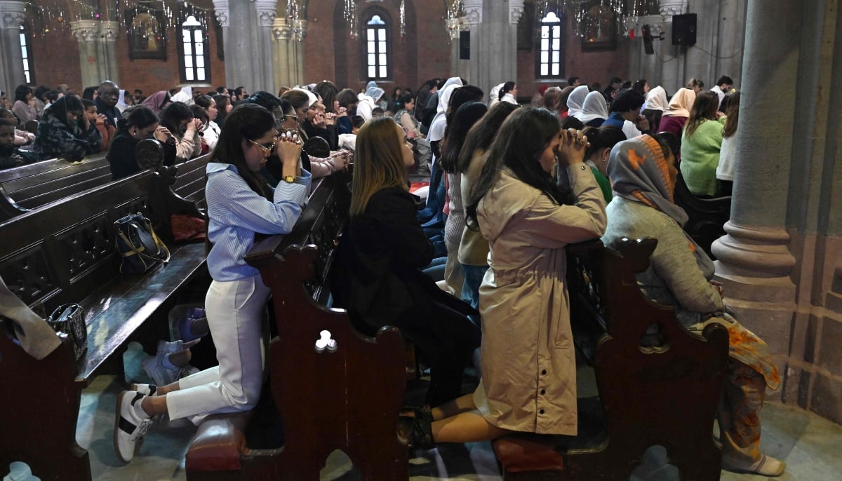 Christians pray during Christmas mass at Sacred Heart Cathedral in Lahore on December 25, 2025. — AFP