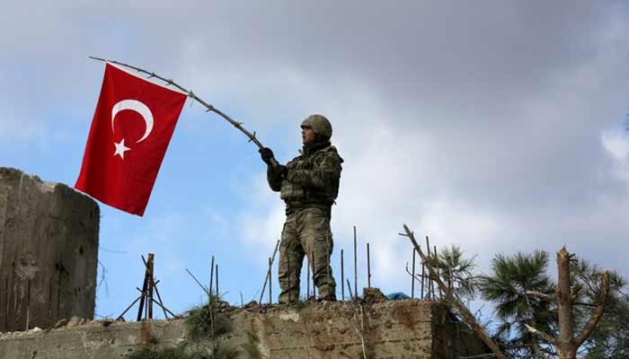 A Turkish soldier waves a flag on Mount Barsaya. —Reuters/File