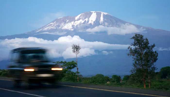 A vehicle moves along a road with Mount Kilimanjaro in the background. — Reuters/File