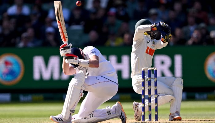 England batsman Gus Atkinson (L) attempts a ramp shot as Australia´s Alex Carey (R) looks on on the first day of the fourth Ashes cricket Test match between Australia and England at the Melbourne Cricket Ground (MCG) in Melbourne on December 26, 2025. — AFP