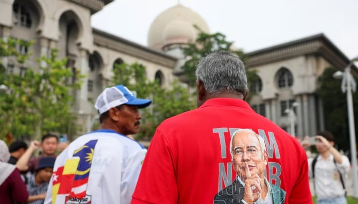 A supporter wears a shirt with former Malaysian Prime Minister Najib Razaks potrait printed on it, outside the Palace of Justice in Putrajaya, Malaysia, December 26, 2025. — Reuters